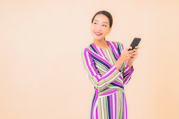 Gebruik van de portret mooie jonge Aziatische vrouw slimme mobiele telefoon op kleur