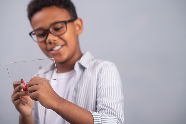 Geconcentreerd schoolkind schrijven op een dun plat stuk glas