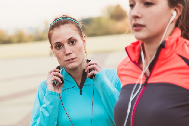 Geconcentreerd sportvrouw met de handen op de koptelefoon