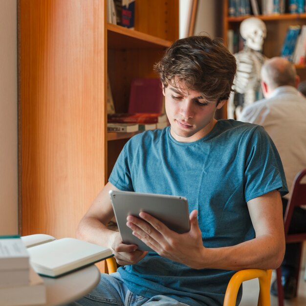 Geconcentreerde man met tablet in handen