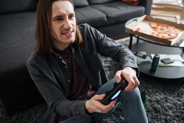 Geconcentreerde man om thuis te zitten spelen spelletjes