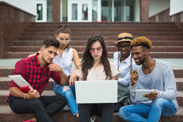 Gratis foto geconcentreerde studenten met laptop buiten