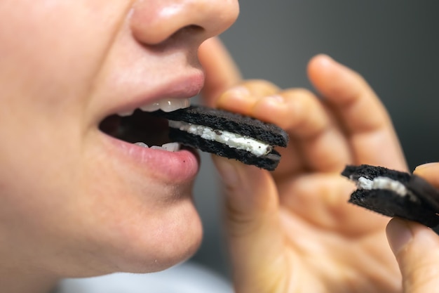 Gedetailleerd shot van een vrouw die in een chocoladekoekje bijt