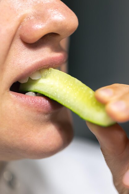 Gedetailleerde opname van een vrouw die verse komkommers eet