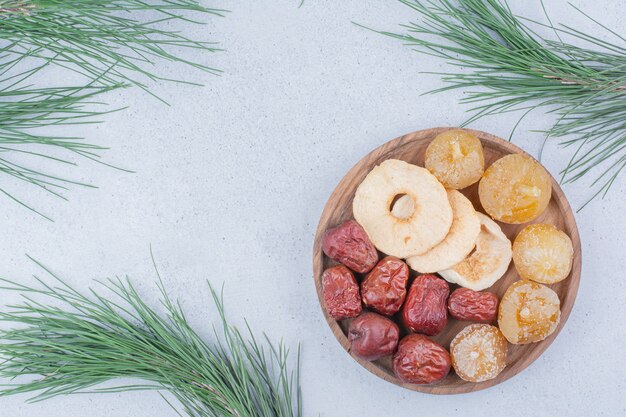 Gedroogd fruit en zilverbes op houten plaat.