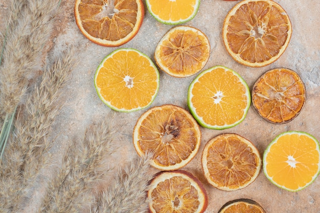 Gedroogde en verse stukjes sinaasappel op marmeren achtergrond.