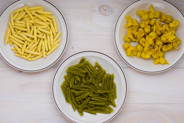 Gedroogde Italiaanse spinazie casarecce; Garganelli en tortellini pasta op houten achtergrond