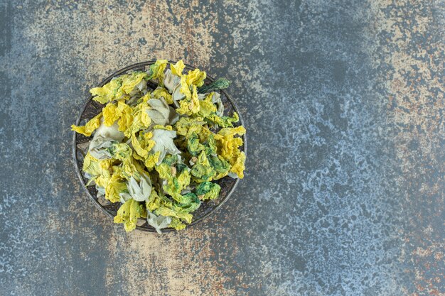 Gedroogde natuurlijke gele bloemen in metalen kom.