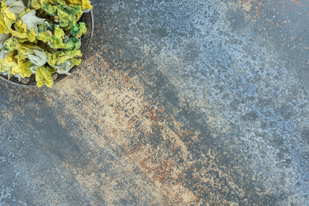 Gedroogde natuurlijke gele bloemen in metalen kom.