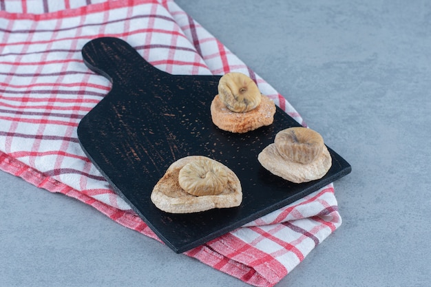 Gedroogde vijgen op de snijplank, op de handdoek, op de theedoek, op de marmeren tafel.