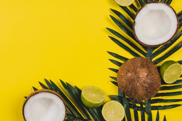 Geel oppervlak met zomervruchten en palmblaadjes