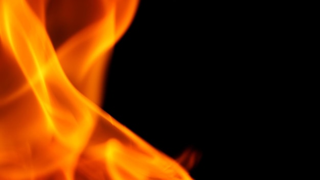 Geeloranje en rode kleur van vuur is vlammend en verbrandt de hitte op zwarte achtergrond en close-up shot.