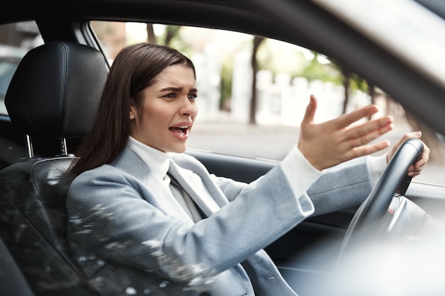 Geërgerd zakenvrouw die vastzit in het verkeer tijdens haar woon-werkverkeer.