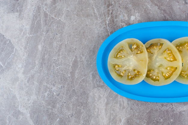 Gefermenteerde tomatenplakken op blauw bord.