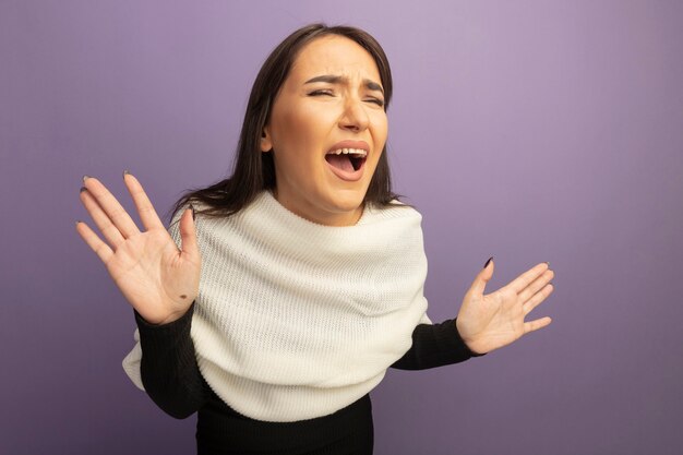 Gefrustreerde jonge vrouw met witte sjaal die en wild schreeuwt schreeuwt