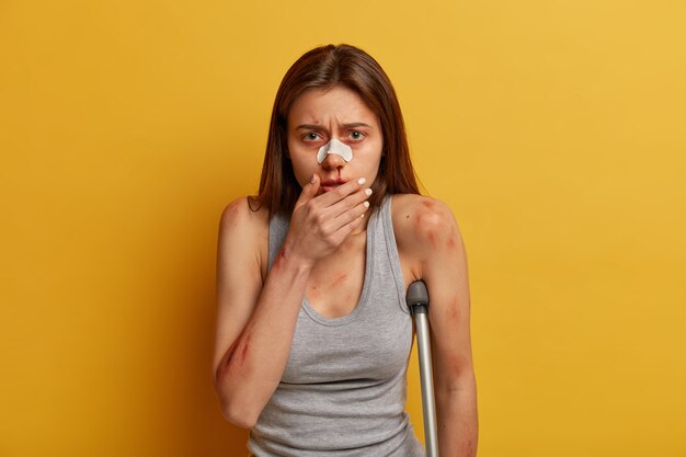 Gefrustreerde teleurgestelde vrouw heeft bloedneus na uitglijden op ijs, gebroken been