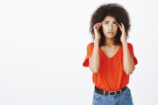 gefrustreerde vrouw met afro kapsel poseren in de studio