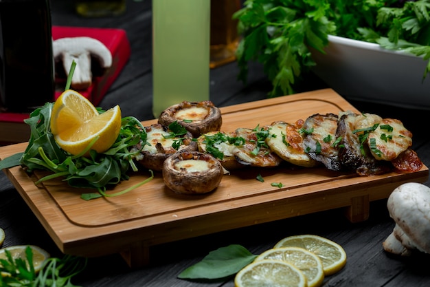 Gegrilde champignons en aardappelen op een houten bord