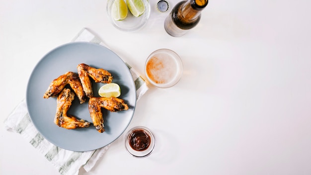 Gegrilde vleugels in de buurt van saus en bier