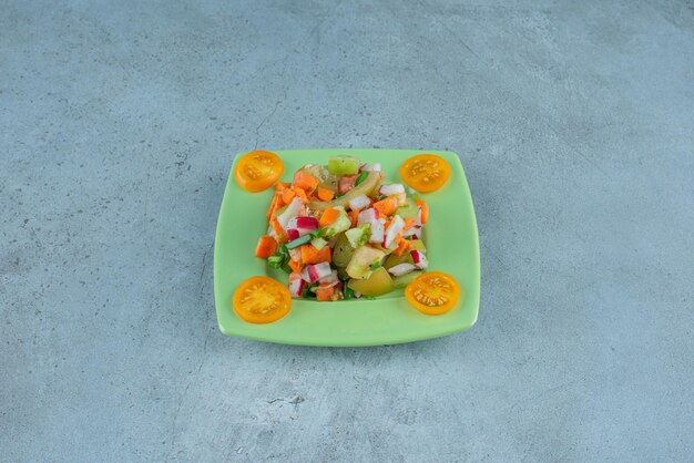 Gehakte fruitsalade in een keramische plaat op beton.