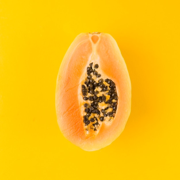 Gehalveerd papajafruit op gele achtergrond