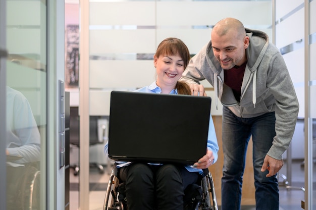 Gehandicapte jonge vrouw in kantoor met een collega