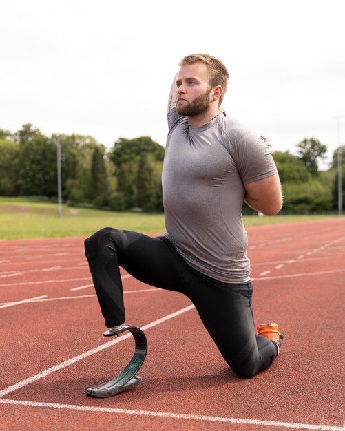 Gehandicapte man op atletiekbaan die volledig schot uitrekt