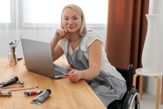 Gehandicapte persoon in rolstoel die aan laptop werkt