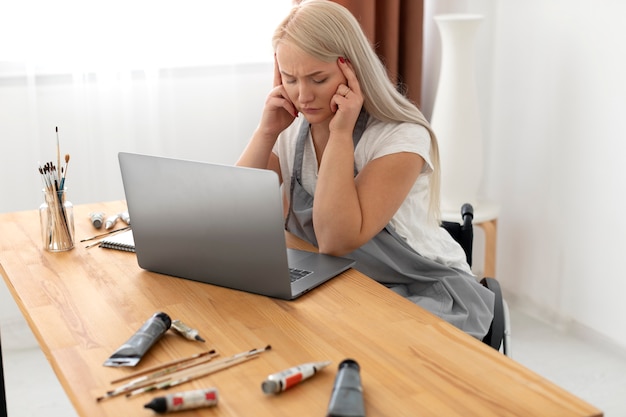 Gehandicapte persoon in rolstoel die aan laptop werkt