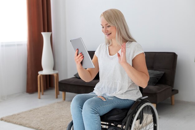 Gehandicapte persoon in rolstoel met behulp van digitaal apparaat