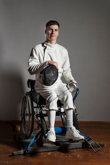 Gehandicapte schermer in speciale uitrusting zittend in een rolstoel
