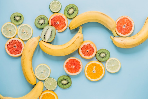 Gehele bananen dichtbij gesneden fruit