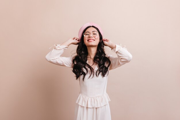 Geïnspireerd chinese dame poseren in baret. Vooraanzicht van vrolijk Aziatisch meisje in trendy outfit.