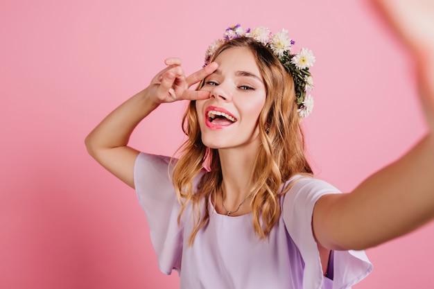 Geïnspireerde blonde vrouw in paarse kleding tijd doorbrengen in de studio