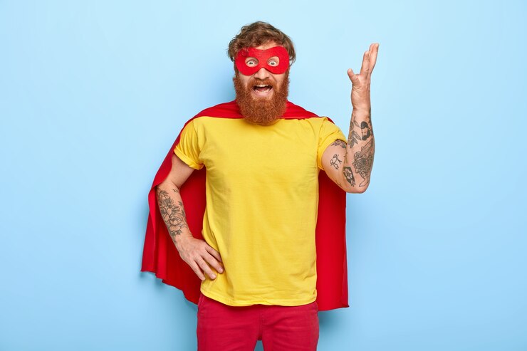Gratis Foto geïrriteerde superheld heft arm op en gebaart van ergernis, heeft veel werk