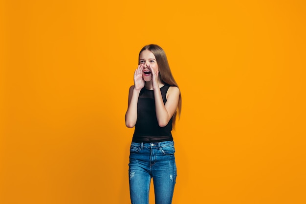 Geïsoleerd op gele jonge casual tiener meisje schreeuwen