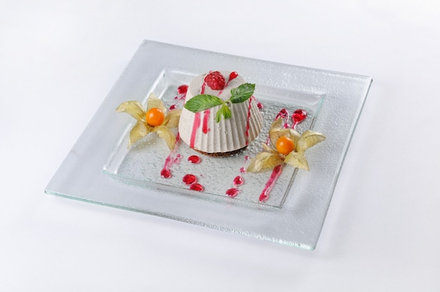 Geïsoleerd schot van een dessert met frambozen en physalis