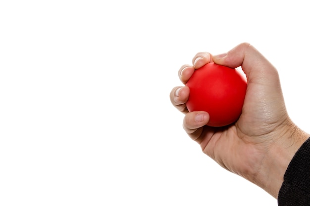 Geïsoleerde afbeelding van een persoon die een rode bal knijpt