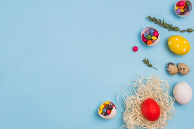 Gekleurd ei in nest met suikergoed op lijst