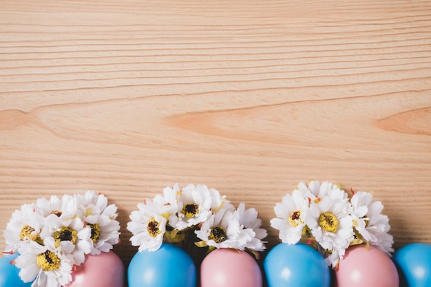 Gratis foto gekleurde eieren dichtbij bloemhoofden