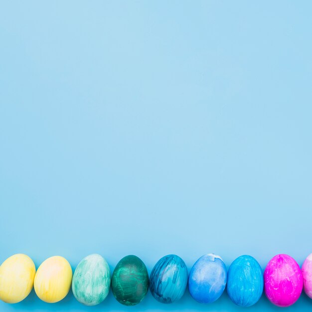Gekleurde eieren op blauwe achtergrond
