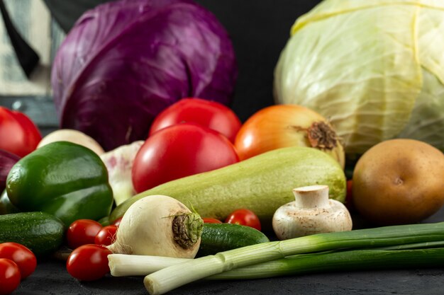 Gekleurde groenten verse rijpe salade groenten zoals groen merg en anderen op grijs bureau