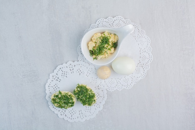 Gekookte eieren met greens op witte achtergrond.