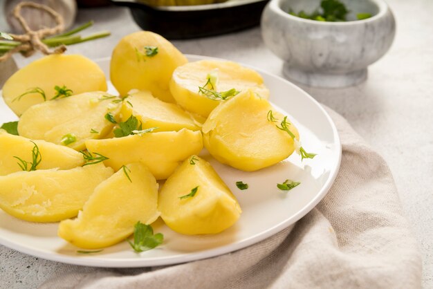 Gekookte gehakte aardappelen op witte plaat