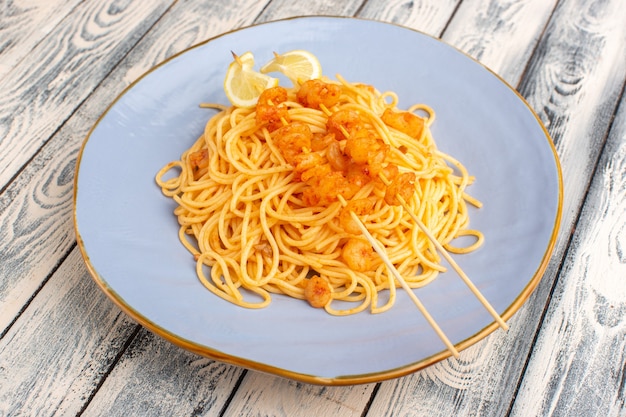 gekookte Italiaanse pasta lekker in blauw bord op grijs hout