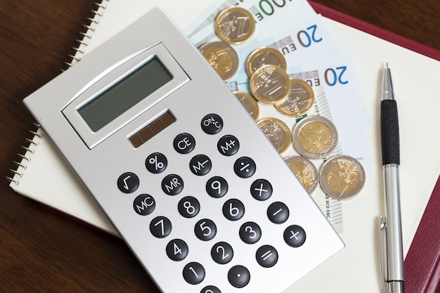 Geld, Kladblok en rekenmachine op tafel