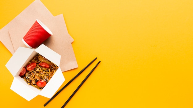 Gratis foto gele achtergrond met chinees eten