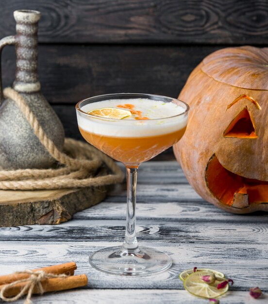 Gele cocktail met sinaasappel op de lijst