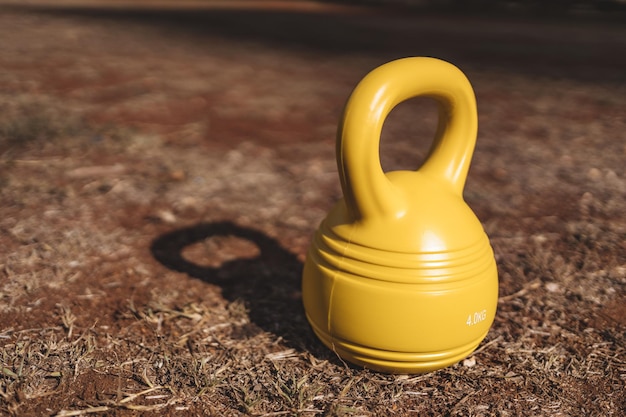 Gele kettlebell op de grond in het park