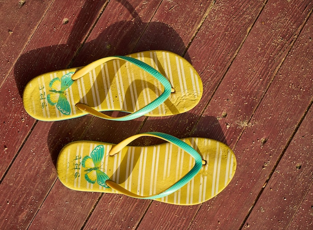 Gratis foto gele sandals op hout